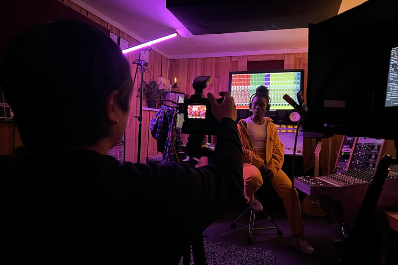 people inside a recording studio lit by pink lighting